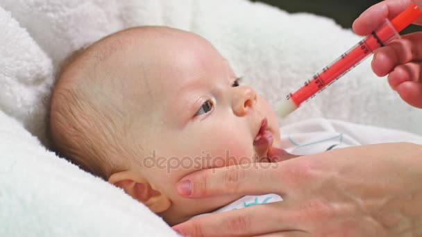 Малышка принимает лекарства с помощью шприца — стоковое видео