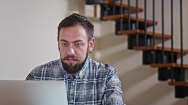 Evde dizüstü bilgisayarla çalışan bir adam