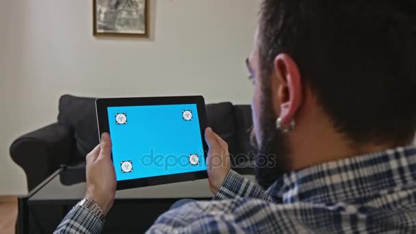 Uomo con una tavoletta digitale con movimento schermo blu — Video Stock
