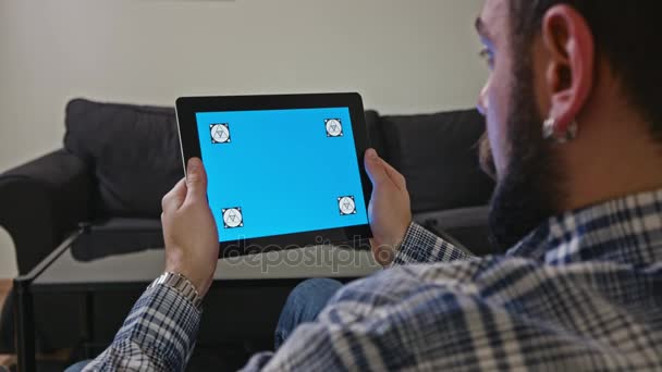 Ο άνθρωπος με μια ψηφιακή δισκίο με μπλε οθόνη κίνησης — Αρχείο Βίντεο