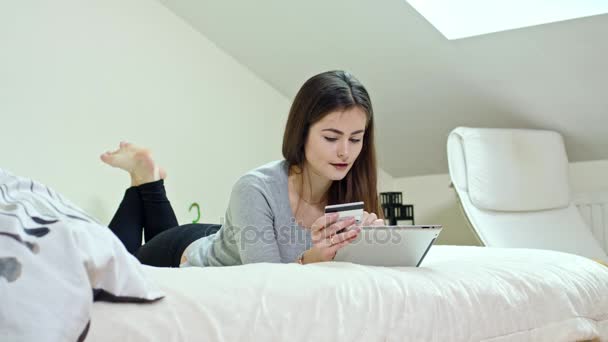 Mujer usando una tableta digital acostada en casa — Vídeo de stock