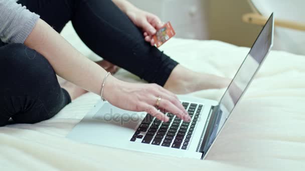 Женщина с ноутбуком сидит на кровати дома — стоковое видео