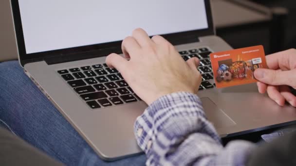 Hombre escribiendo número de tarjeta de crédito en el ordenador portátil — Vídeos de Stock