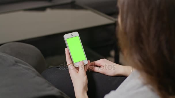 Женщина держит смартфон с голубым экраном — стоковое видео