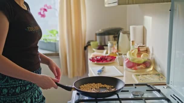 Kobieta, prażenie orzechów ziemnych na patelni — Wideo stockowe