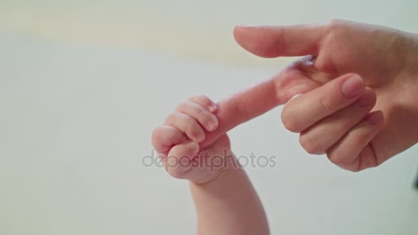 Madres dedo está sosteniendo puño Babys — Vídeo de stock