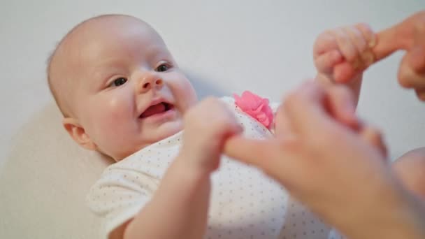Lindo bebé está jugando con las manos de las madres sonriendo sorprendente — Vídeo de stock