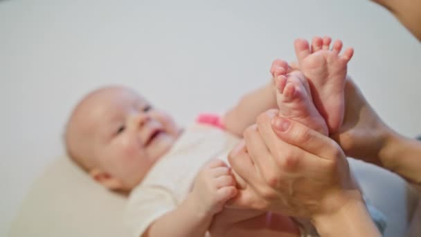Мать целует младенцев ногами — стоковое видео