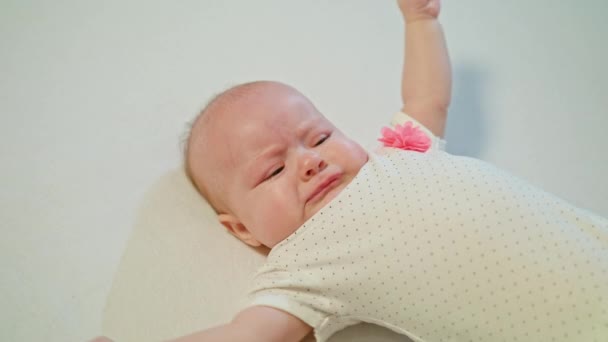 Baby Mädchen, das auf Bett liegt, fängt an zu weinen — Stockvideo