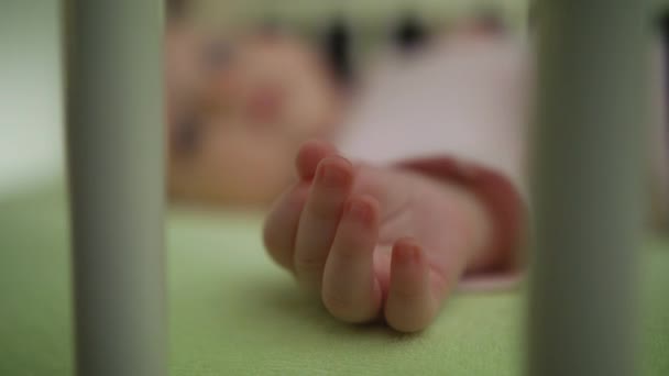 赤ちゃんベビーベッド モーション閉じるを手に背中に横たわる — ストック動画