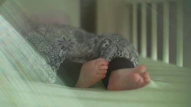 Babys fot i byxor skakar i sängen med linsen Flare — Stockvideo