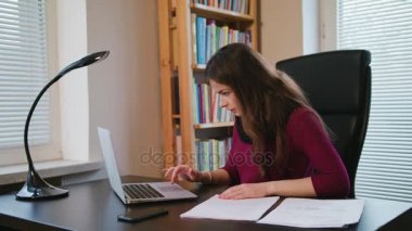 Belgeler üzerinde arayan ciddi genç kadın.