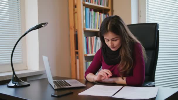 Серьезная молодая женщина просматривает документы . — стоковое видео