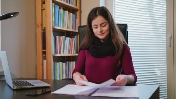 Wesoła, młoda kobieta, patrząc na dokumenty. — Wideo stockowe