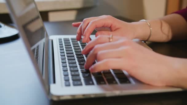 Manos femeninas escribiendo texto en el teclado del ordenador portátil — Vídeo de stock