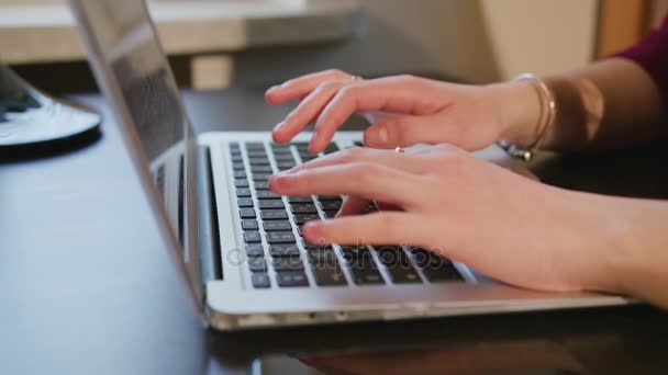 Manos femeninas escribiendo texto en el teclado del ordenador portátil — Vídeo de stock