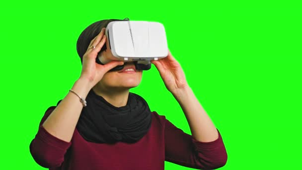 Mujer girando la cabeza con un auricular VR encendido . — Vídeos de Stock