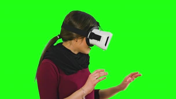 Mujer girando la cabeza con un auricular VR encendido . — Vídeos de Stock