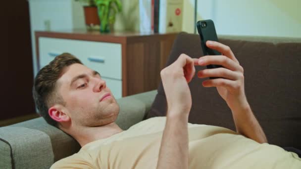 Man Laying on the Sofa and Using Mobile Phone — Stock Video