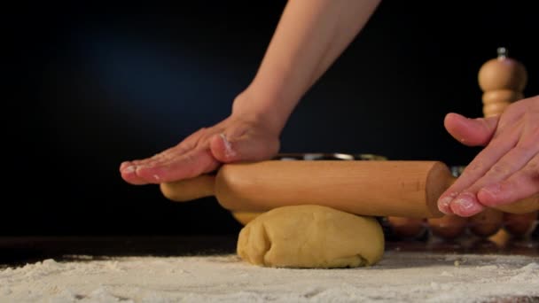 Женские руки разворачивают тесто на столе — стоковое видео