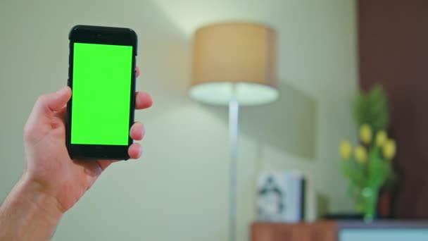 Una mano che tiene un telefono con uno schermo verde e nero — Video Stock