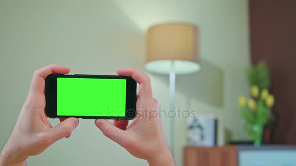 Mani maschili che tengono un telefono con uno schermo verde — Video Stock