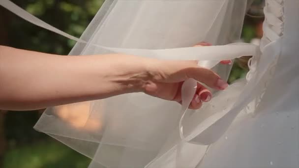 Une demoiselle d'honneur aider à lacer une robe de mariée — Video