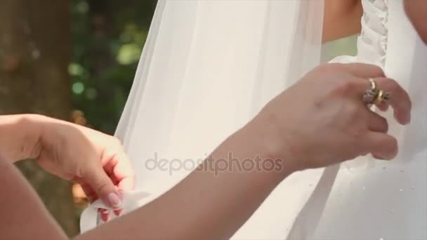 Una dama de honor ayudando a atar un vestido de novia — Vídeos de Stock