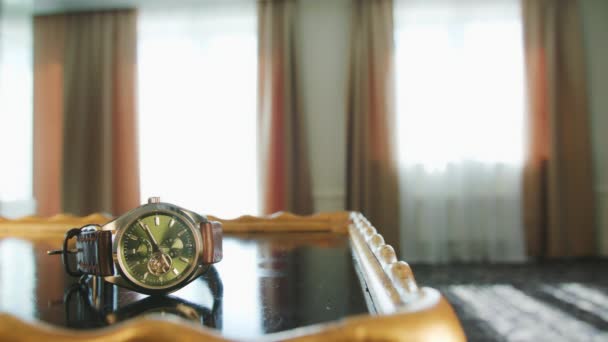 Un hombre tomando un reloj de la mesa — Vídeos de Stock