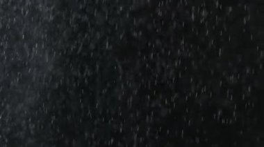 Düşen yağmur veya kar siyah bir arka plan.