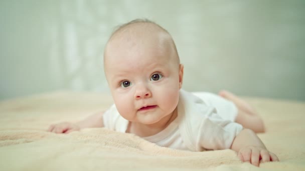 Baby Lying on Stomach on a Soft Linen Smiling — Stock Video