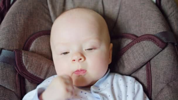 Lindo bebé acostado en Pram comiendo sus dedos — Vídeos de Stock