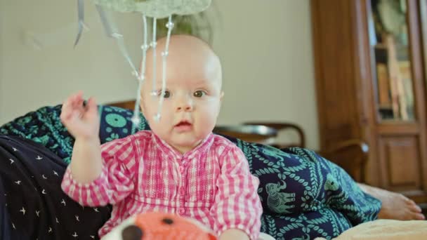 Bebê sentado e brincando com um brinquedo — Vídeo de Stock