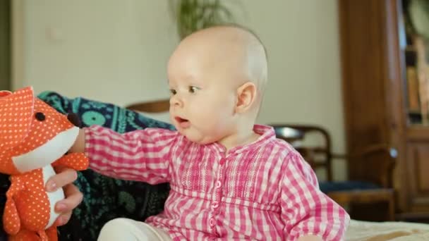 Bebê sentado e brincando com um brinquedo — Vídeo de Stock