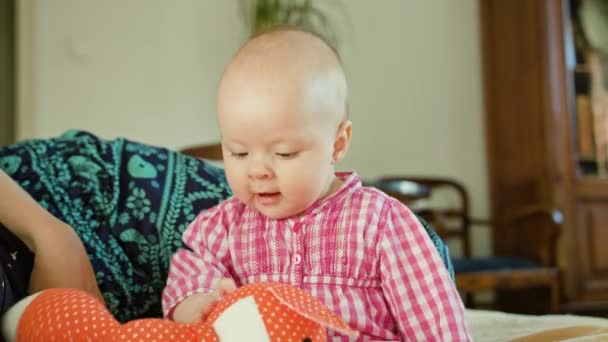 Το μωρό κάθεται και να παίζει με ένα παιχνίδι — Αρχείο Βίντεο
