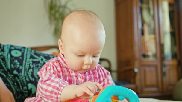 Bebê sentado e brincando com um brinquedo — Vídeo de Stock