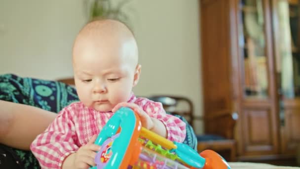 Bebê sentado e brincando com um brinquedo — Vídeo de Stock