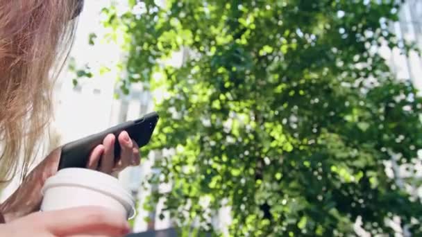 Vrouw met behulp van een telefoon in het Park — Stockvideo