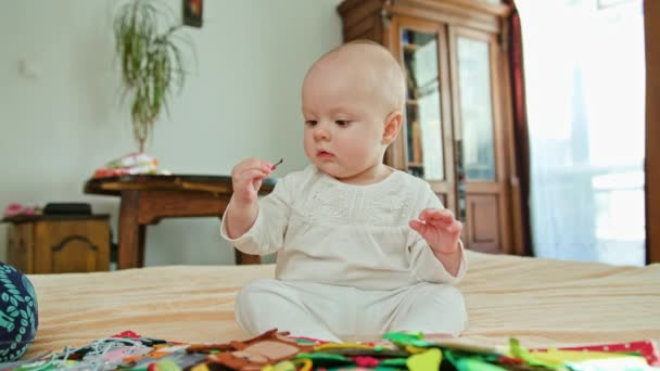 Bebê sentado e brincando com um brinquedo — Vídeo de Stock