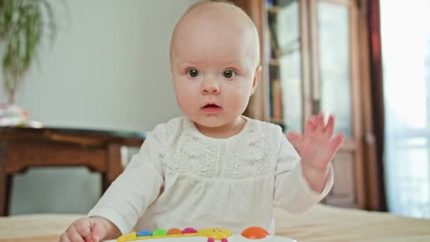 Bebê sentado e brincando com um brinquedo — Vídeo de Stock