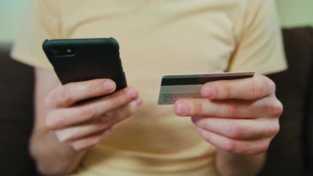 Mann kauft mit Kreditkarte und Smartphone ein — Stockvideo