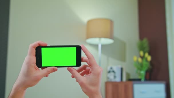 Manos masculinas sosteniendo un teléfono con una pantalla verde — Vídeo de stock