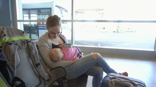 Une femme allaite son enfant à l'aéroport — Video