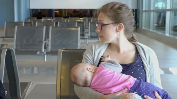 Una mujer amamantando a su hijo en el aeropuerto — Vídeos de Stock