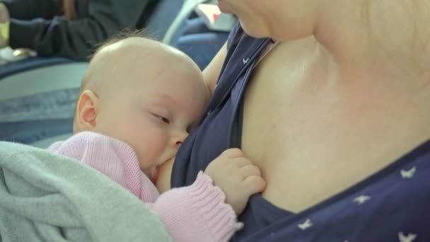 Een vrouw borstvoeding haar kind op een vliegtuig — Stockvideo