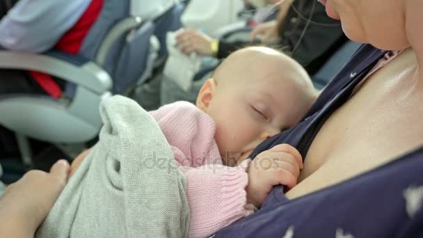 Bir kadın emzirme çocuğunu bir uçakta — Stok video
