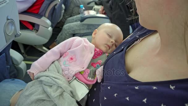 Женщина, держащая своего ребенка в самолете — стоковое видео