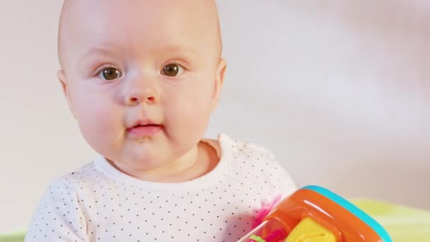 Bebê sentado e brincando com um brinquedo — Vídeo de Stock