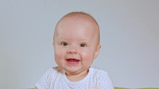 Baby sitzt und lächelt — Stockvideo