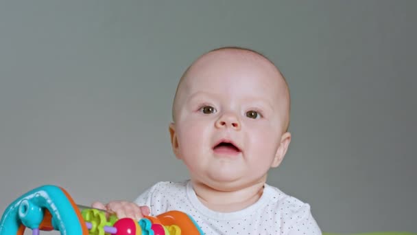 Bebê sentado e brincando com um brinquedo — Vídeo de Stock